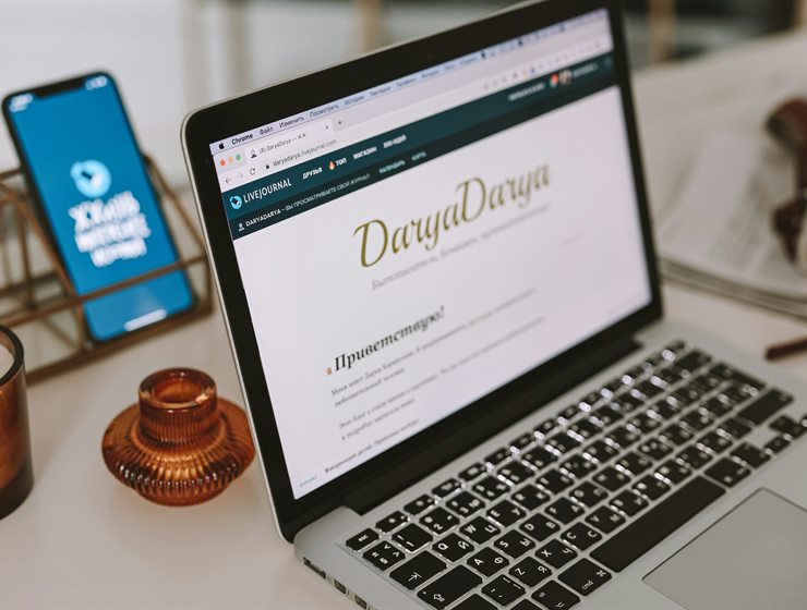 A product page open on a phone beside a laptop
