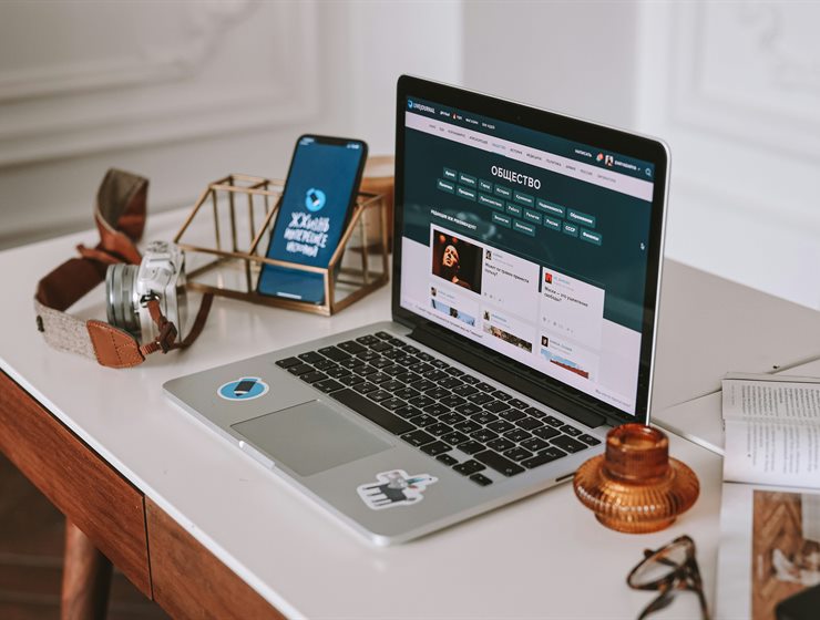 A laptop and phone on a desk showing a storefront design
