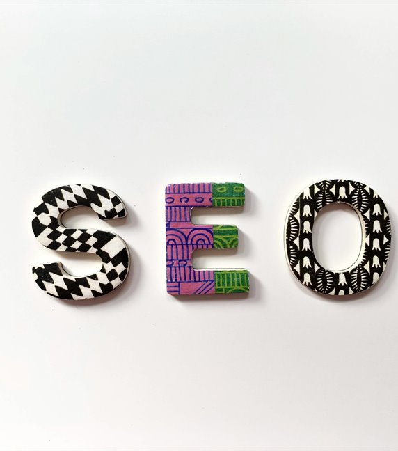 The letters S E O laid out on a white surface