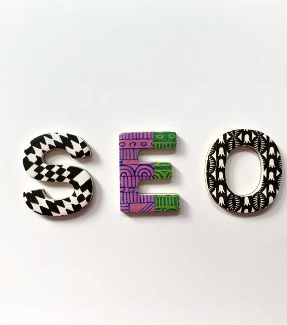 The letters S E O laid out on a white surface