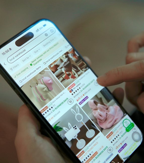 A storefront loading on a phone held in front of a desk