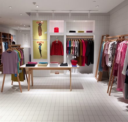 Clothing rail and display table in a styled store